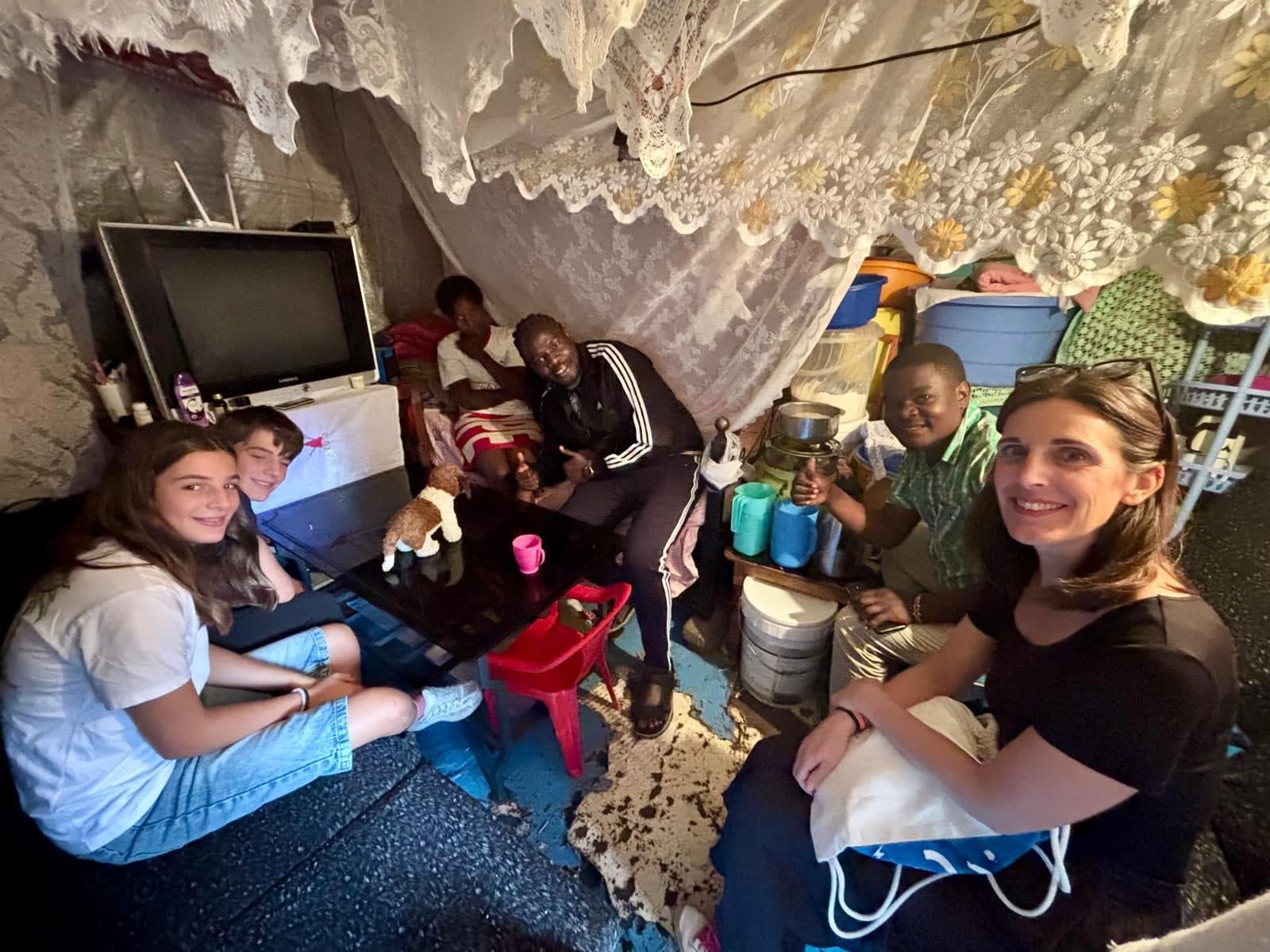 Guests sitting with a family inside their home in Kibera